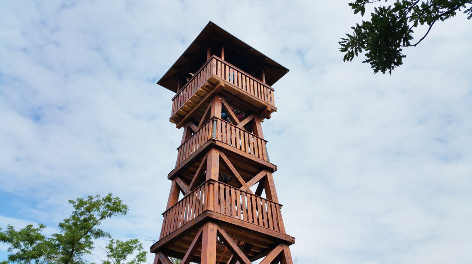 Z rozhľadne nad obcou vidieť maďarské pohoria i Zobor